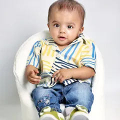 An individual portrait of the other twin, looking sharp in his casual outfit. These solo shots perfectly complement the photos of them together.