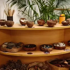 Our environment is the third teacher. We intentionally curate shelves with natural, open-ended materials like stones, pinecones, and seed pods. These "loose parts" invite children to imagine, create, and construct their own stories, transforming simple objects into anything their minds can conceive.