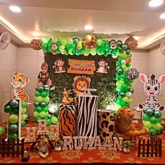 A classic jungle animal theme for Ruhaan's first birthday. This setup includes a greenery backdrop, cute animal cutouts like a giraffe and tiger, and balloon columns to bring the friendly jungle to life.