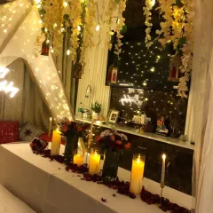 The full view of our romantic dinner setup, including a canopy tent adorned with hanging flowers and fairy lights for a magical feel.