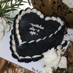 Casting a spell for eternal youth, one bite at a time. This black heart-shaped cake with the quote "witches don't age" is perfect for a spooky, chic birthday.