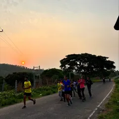 Campers on a morning jog along a scenic road as the sun rises. Physical fitness is a key component of our youth leadership camps, building endurance and discipline.