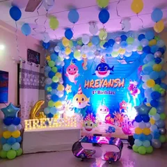 An underwater adventure with a Baby Shark theme for a 4th birthday. I used a large printed backdrop, a blue and yellow balloon arch, and an illuminated name sign to create a vibrant sea world for the party.