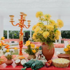 A close-up of a table centerpiece from our 'Haldi Holi' event. We even sprinkled some of the holi colors onto the flowers themselves, a fun little detail that tied everything together perfectly.