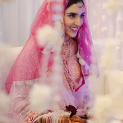 The bride's joyful smile during her "Qabool Hai" moment. Framed by flowers, this shot captures the happiness and beauty of her acceptance.