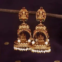 These traditional temple jhumkis have a matte gold finish and feature a beautiful Goddess Lakshmi motif. This pair is adorned with classic pearl drops, adding to their timeless elegance.