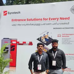 Our team standing proudly beside a banner showcasing our "Entrance Solutions for Every Need" at the Autosec Expo in Kerala. We offer everything from toll management to residential and commercial parking solutions.