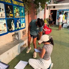 A coach taking detailed notes during a player assessment. We track progress closely to tailor our training programs for each individual.