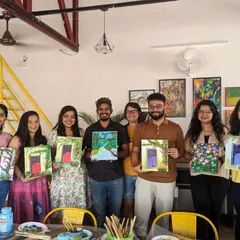 A happy group from our canvas painting meetup, all showing off their unique paintings of doors and flowers. It's so much fun to see how everyone interprets the same theme differently.