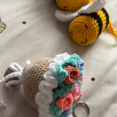 A cute crochet creation featuring a honey bee and a flower bucket keychain. These small items are perfect for unique gifts.