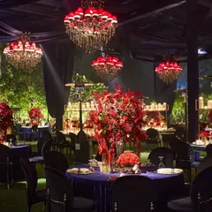 For this cocktail night, we created a secret world of red and blue. The space was defined by deep blue velvet tablecloths and dramatic red chandeliers, with lush red floral centerpieces adding to the passionate and opulent atmosphere.