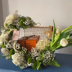 Even the most luxurious gifts deserve a presentation that matches their grandeur. Here, I've created a stunning setting for an iconic orange box, nestled within a golden birdcage and surrounded by fresh white tulips, carnations, and baby's breath.
