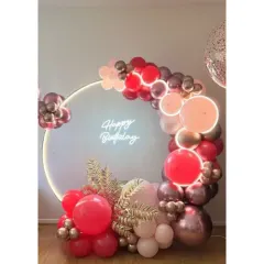A gorgeous and modern ring light backdrop. The neon "Happy Birthday" sign is surrounded by a cascade of red, pink, and metallic balloons for a vibrant and chic look.