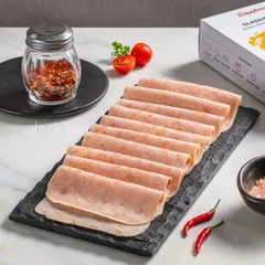 Slices of chicken salami elegantly arranged on a slate platter, with the Zappfresh product box visible in the background.