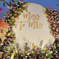 A lovely "Miss to Mrs" photo backdrop for a bridal shower or Mehendi. The circular white board is framed with a beautiful arrangement of pastel flowers.