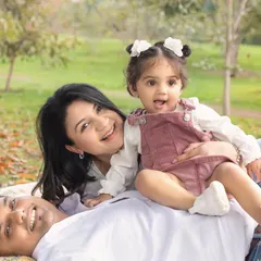 A playful moment with their daughter. The low angle and green background create a beautiful, immersive feel.