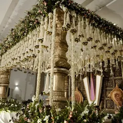 This is what we mean by luxe tradition. This grand temple-style mandap features massive carved pillars and a dense canopy of jasmine strings, creating a breathtaking sacred space for a South Indian wedding.