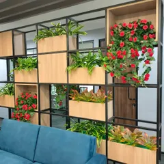 For this corporate office, we designed and built a functional and aesthetic partition wall. The metal and wood frame incorporates numerous planters with a variety of artificial plants, including vibrant red roses, creating privacy and a natural feel in the workspace.