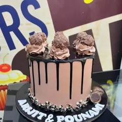 A classic 1kg chocolate drip cake topped with swirls of chocolate frosting and Ferrero Rocher chocolates.