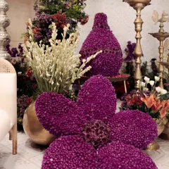 Floral artistry at its best. For the "Garden of Vows" theme, I created these large, sculptural flowers and vases made entirely of deep purple gomphrena blooms, adding a unique and artistic touch to the decor.