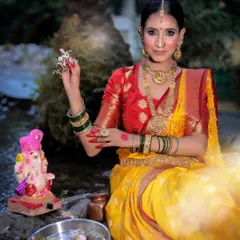 The model offers flowers to a Ganesha idol, her expression one of devotion in this culturally rich portrait.
