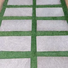 A very popular and modern design is combining artificial grass with natural stone pavers. This creates a durable and stylish pathway that is perfect for garden walkways or entrance areas.