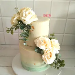 A stunning pastel green and white two-tier engagement cake, proving that simple and classic is always beautiful. I adorned this no-fondant cake with fresh white roses and eucalyptus for a fresh, elegant feel.