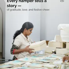 Every hamper tells a story of gratitude, love, and festive cheer. A team member carefully handles a gift box, ensuring it's perfect before it goes out.