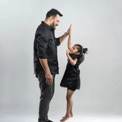 A high-five between a father and his daughter. This dynamic shot captures the fun, energy, and special connection shared between them.
