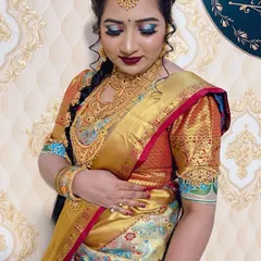 A stunning South Indian bridal look. This features a rich Kanjeevaram saree, heavy temple jewellery, and bold makeup with blue-toned eyeshadow and a deep red lip.