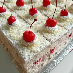 A lighter but equally delicious option, our White Forest pastry. It features vanilla sponge, fresh cream, and cherries, all covered in delicate white chocolate shavings.