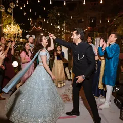 A couple's magical first dance on their sangeet night at Fort Neemrana, surrounded by friends and the warm glow of string lights.