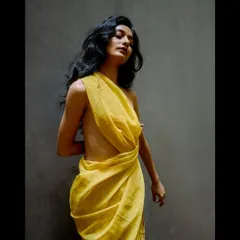 An artistic portrait from a test shoot, selected for a feature on Vogue. The image plays with light and shadow to create a classic, painterly feel, highlighting the draped yellow fabric.