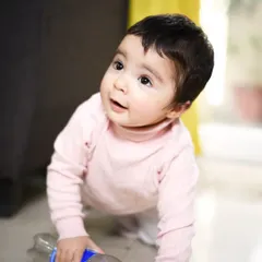 This candid shot captures a baby's natural curiosity as she explores the floor at home. Lifestyle photography is all about finding the beauty in these simple, unposed moments of daily life.