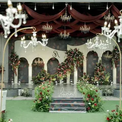 A vision of royal romance, this reception stage combines deep red draping, crystal chandeliers, and lush floral arrangements. It’s a design that speaks of timeless elegance and grandeur.