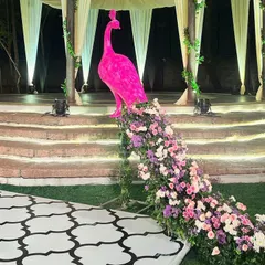 A close-up of our custom-designed pink peacock prop. The tail is a cascade of fresh pink, purple, and white flowers, creating a stunning and unique decor piece.