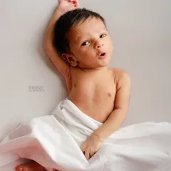 We also love capturing newborns when they are awake and expressive. This little one, resting on a simple white backdrop, gave us a wonderful, curious look that shows off their budding personality.