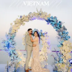 A stunning wedding setup in Vietnam, with a floral arch of blue and white hydrangeas overlooking the water. We find the most picturesque locations for your special day.