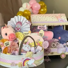 It's a girl! I adore creating these dreamy hampers in shades of pink and purple. This set includes a cozy basket filled with soft toys and essentials, alongside a whimsical trolley hamper, all designed to welcome a little princess in the most beautiful way.