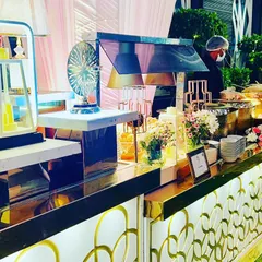 A luxurious buffet counter gleaming with gold accents and sophisticated lighting. This setup demonstrates how we use designer elements to create a high-fashion catering experience for stylish events.