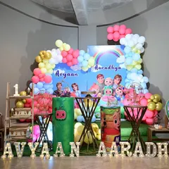 Here is another fun Cocomelon theme, complete with character cutouts, a rainbow backdrop, and light-up marquee letters spelling out the children's names. It's a bright and cheerful setup for young fans.