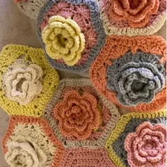 A close-up of hand-crocheted hexagonal flowers from the 'Hope You're Well' installation. These tactile details, made with soft yarns, were central to creating a space focused on wellbeing and empathy.
