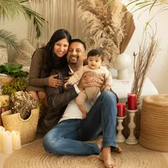 A classic portrait of a young family in my cozy, boho-themed studio. The warm, earthy tones create a relaxed setting for beautiful family photos.