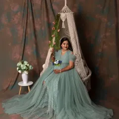 A solo portrait on our whimsical macrame swing. The mom-to-be looks like a queen in her flowing sea-green gown against a classic studio backdrop.
