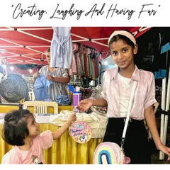 Creating, laughing, and having fun. These two sisters are enjoying our art stall, proudly showing off the personalized nameplate they created together.