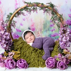 A wider view of our lavender-themed newborn session, showing the baby peacefully asleep in a basket hoop. I use layers of texture and color to create rich, artistic newborn photos.