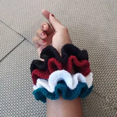 My crochet scrunchies are soft, stylish, and gentle on your hair. Here they are stacked on my wrist, showing off the different colors available.