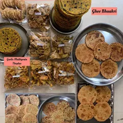 A large assortment of my travel-friendly snacks, featuring Methi Theplas, Ghee Bhakri, Masala Bhakri, and various savory chips. Perfect for long journeys.
