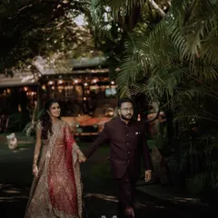 The couple walking hand-in-hand at dusk, the warm lights of the venue creating a romantic and magical atmosphere for their reception.