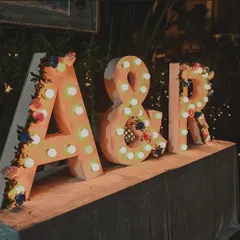 A classic way to personalize your event. I decorated these large, light-up marquee letters of the couple's initials with delicate flowers, creating a perfect photo-op and branding for the wedding.